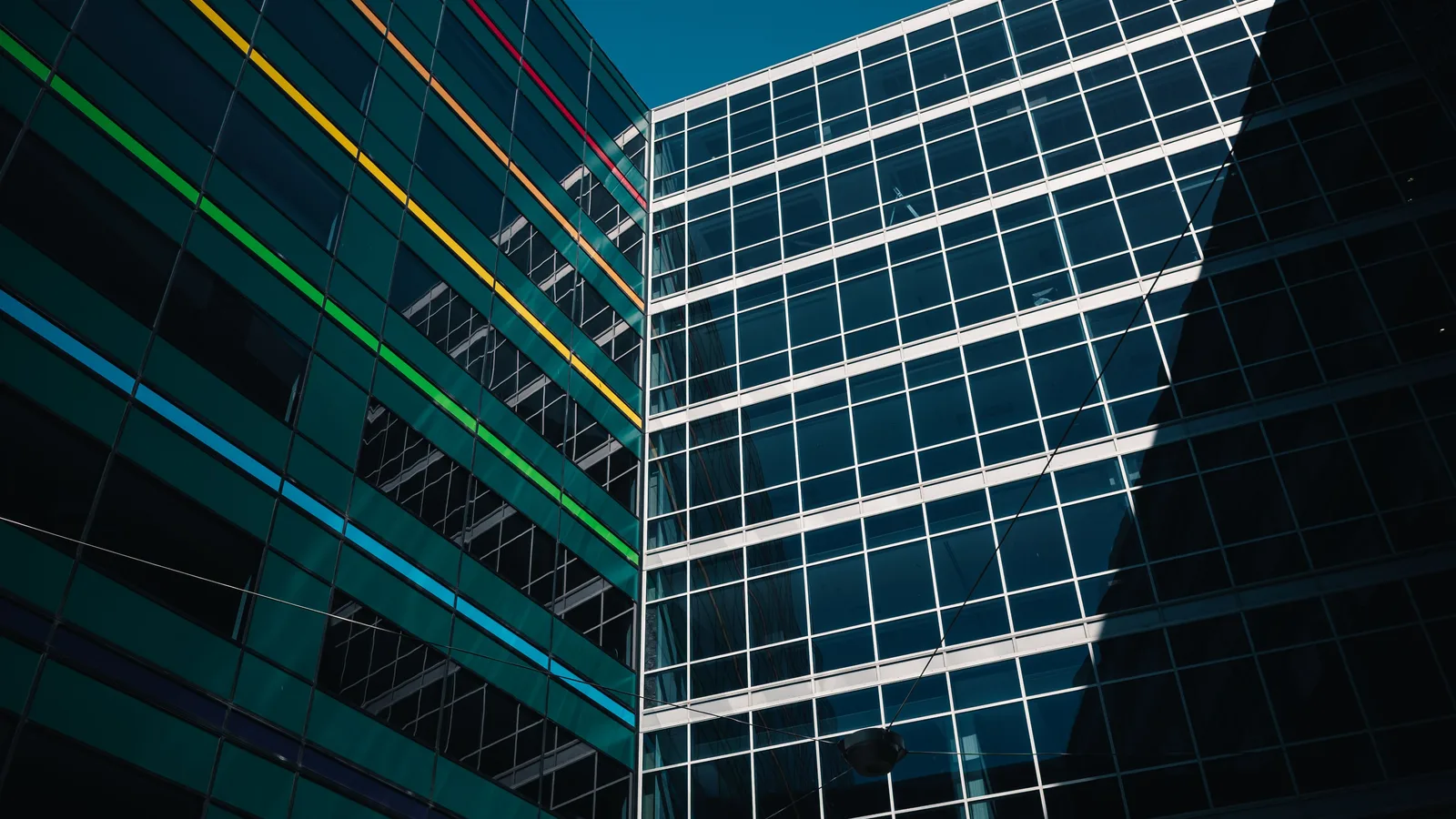 Architectural view of modern commercial buildings with colorful stripes against a clear blue sky