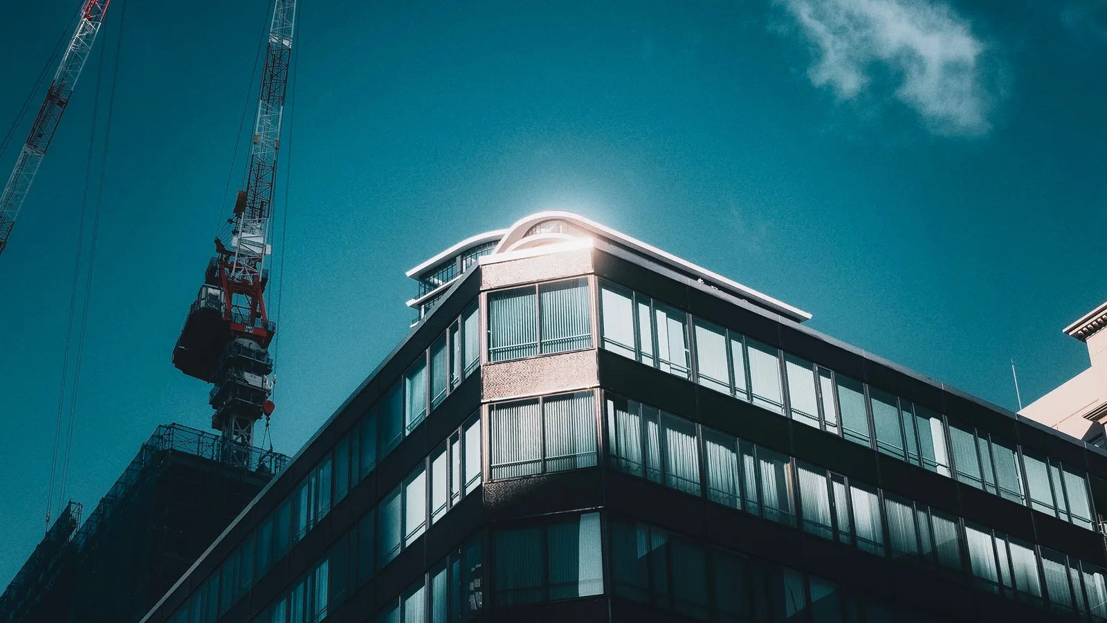 Sunlit modern commercial building with adjacent crane, highlighting property value-add and bridging qualification