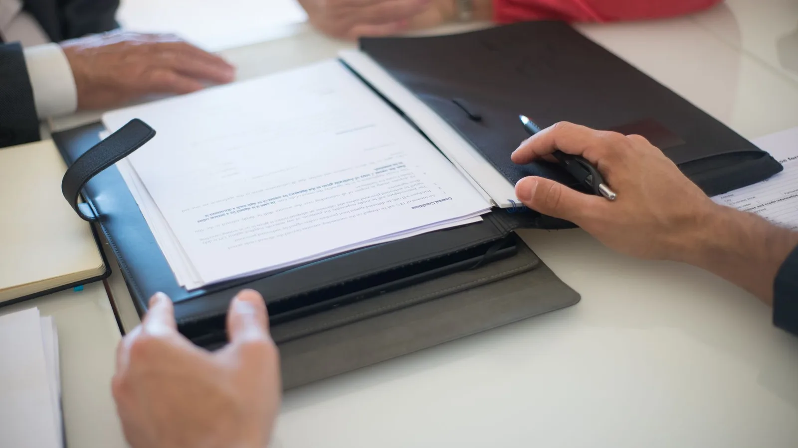 Commercial property borrowers reviewing lending documentation in a professional meeting