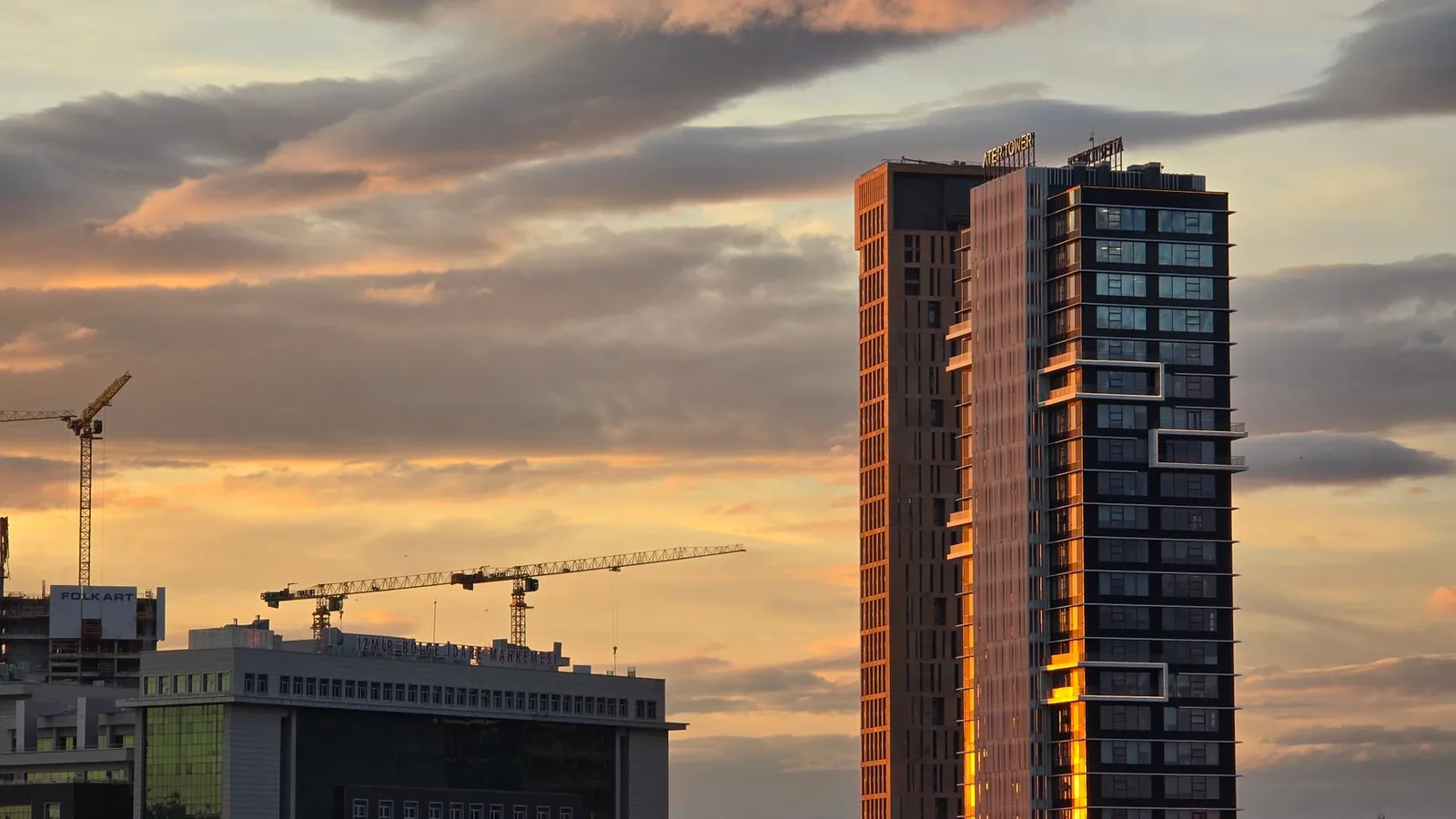 Modern commercial skyscrapers and construction cranes at sunset in New Zealand