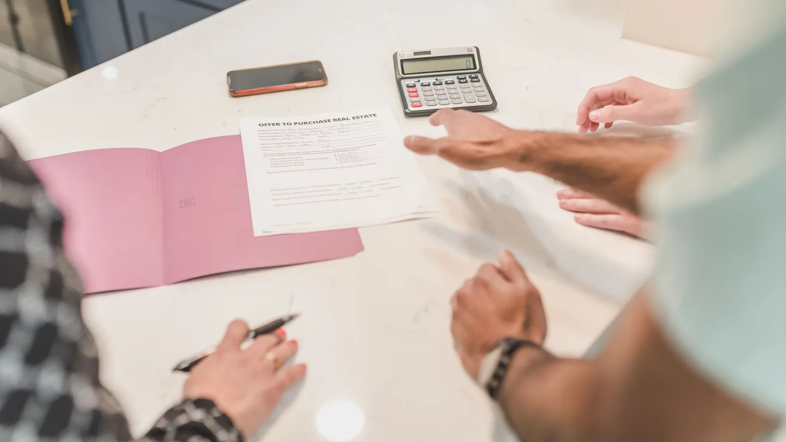 Hands reviewing commercial property financial valuation calculations on an office desk