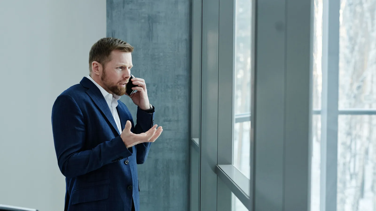 Businessman on a phone call looking out of an office window