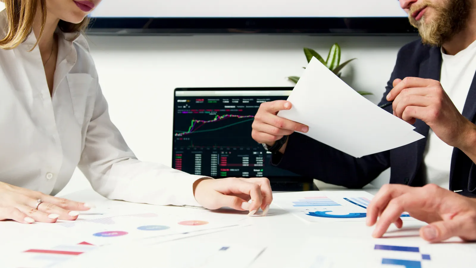 Two finance professionals reviewing paperwork together at a meeting