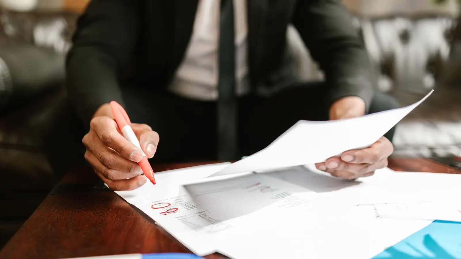 Close-up of a person working through finance documents at a desk