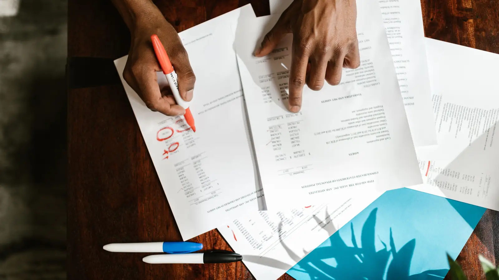 Person working through finance documents at a desk