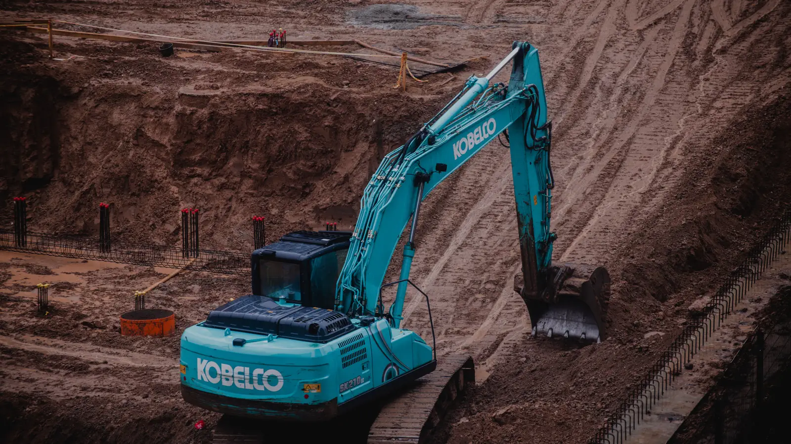 Excavator scooping earth on a construction site, the type of machine funded through construction equipment financing