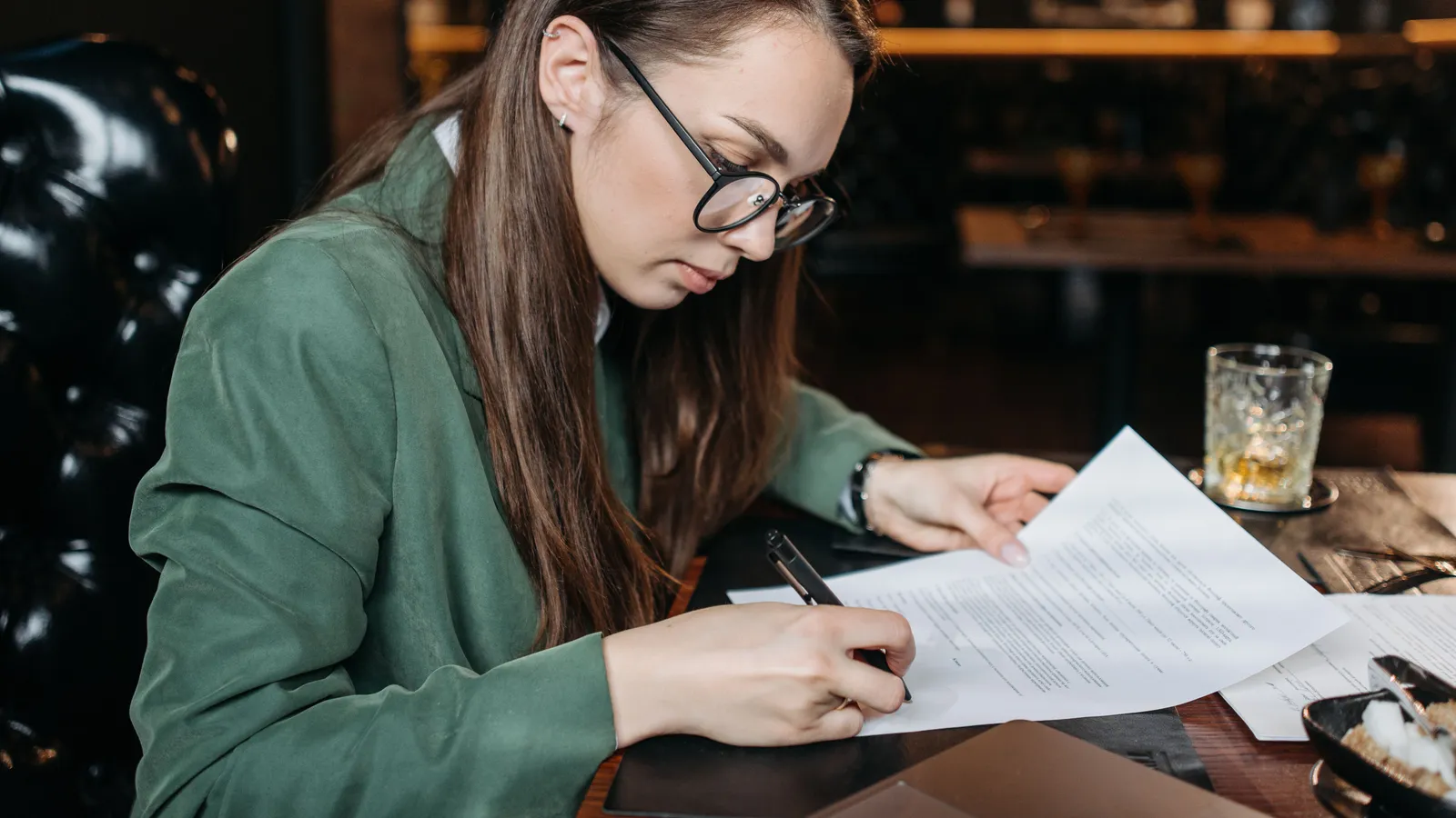 Business owner signing finance documents at a desk