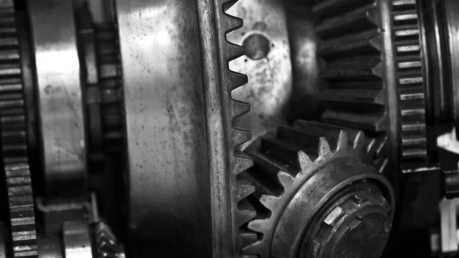 Detailed black and white photo showing close-up of metal gears in an engine, showcasing industrial technology