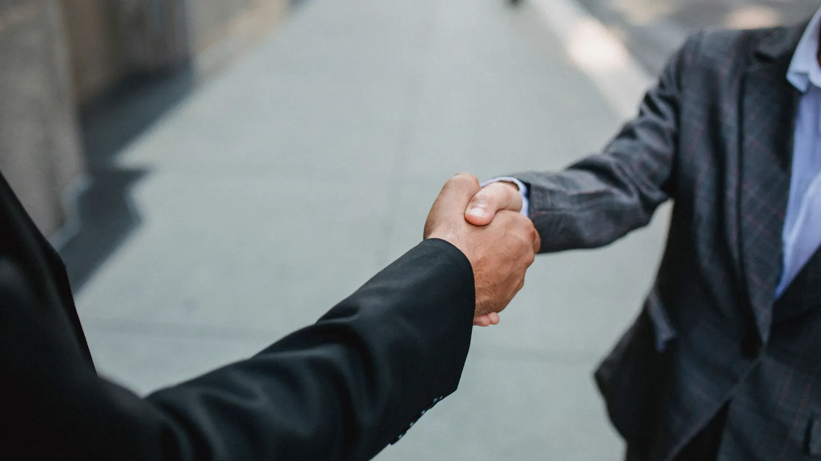 Close-up of two people shaking hands outdoors, symbolising a finalised food truck financing deal