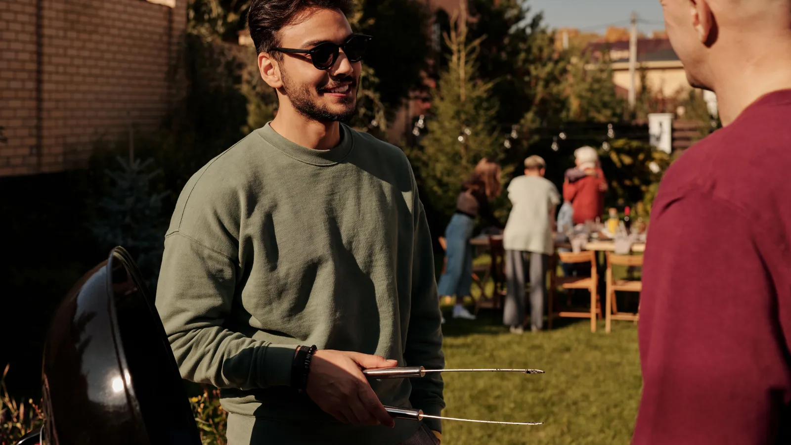Friends gathered around a backyard barbecue, the kind of personal cooking that doesn't need food truck financing