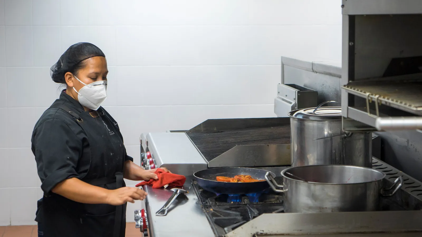 Chef preparing food in a commercial kitchen, the type of fit-out covered by food truck financing alongside the vehicle itself