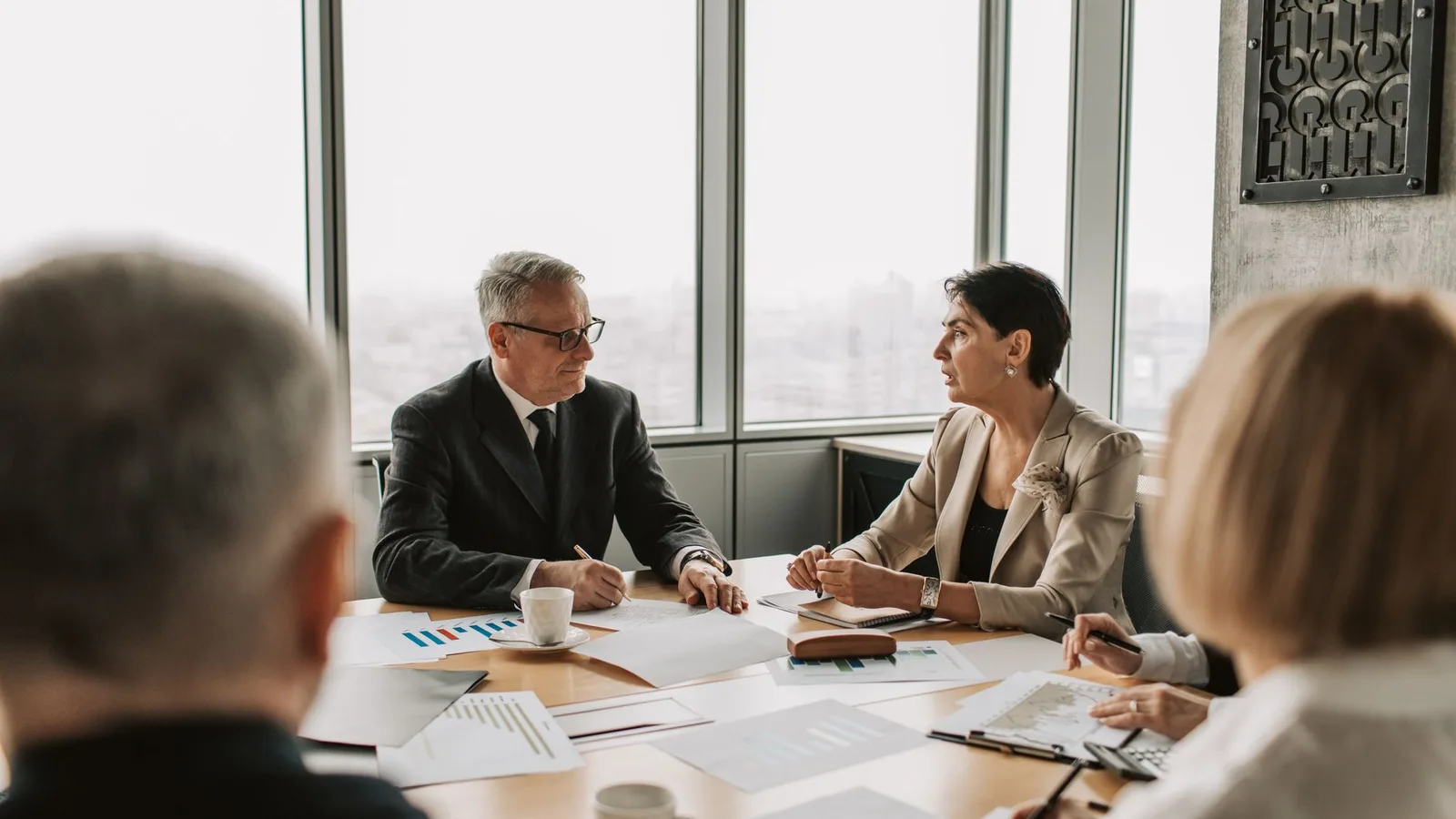 Business executive team discussing invoice factoring versus invoice discounting in a corporate meeting