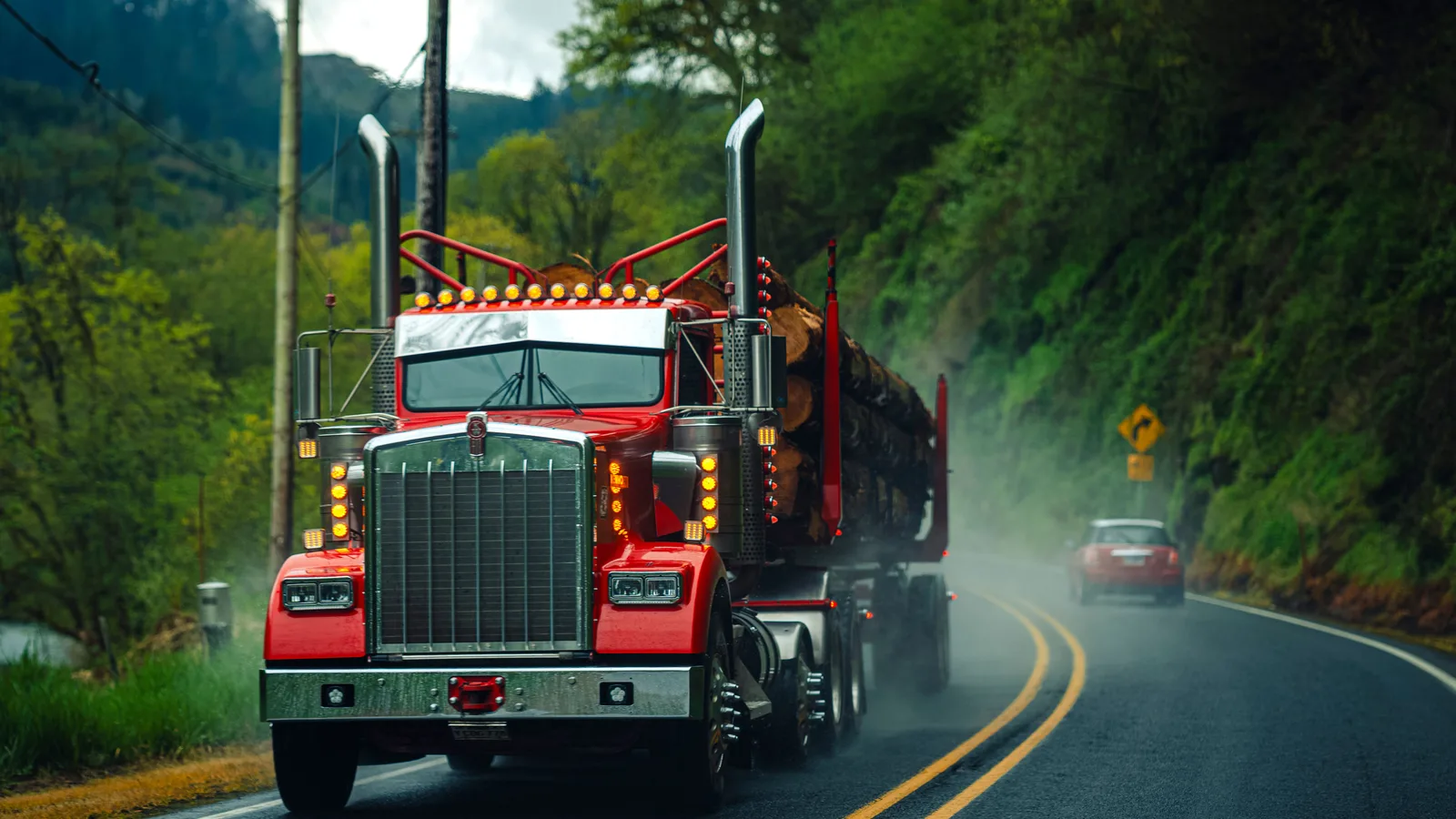 Heavy log truck loaded with freshly harvested timber logs hauling on a highway in New Zealand, funded through log truck financing