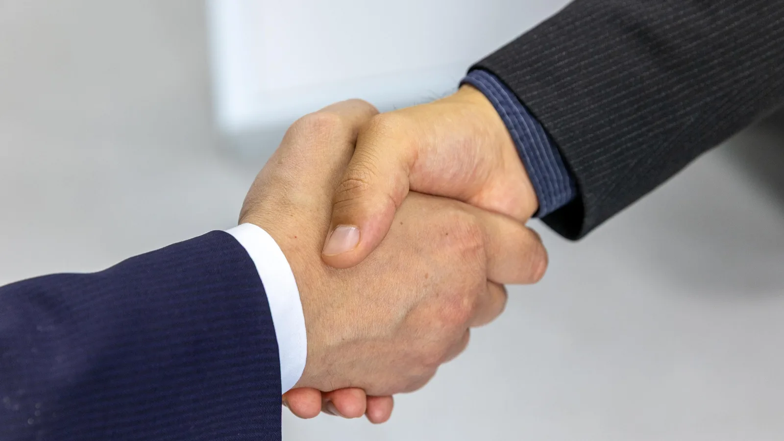 Two finance professionals shaking hands after a business meeting