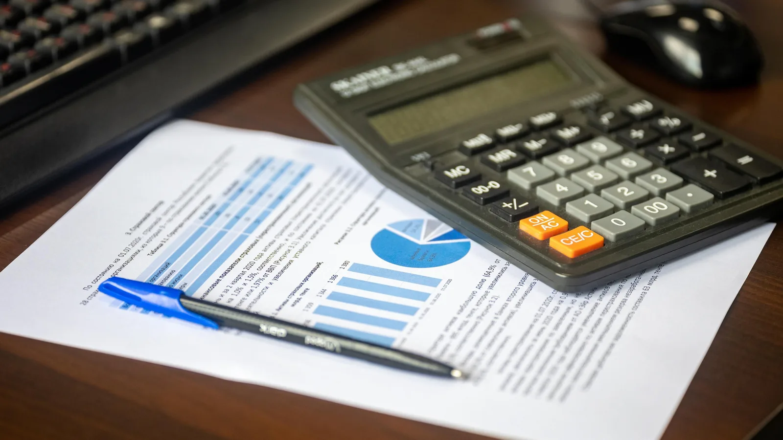 Financial report and calculator on a desk, representing the cost factors behind a motor vehicle finance quote