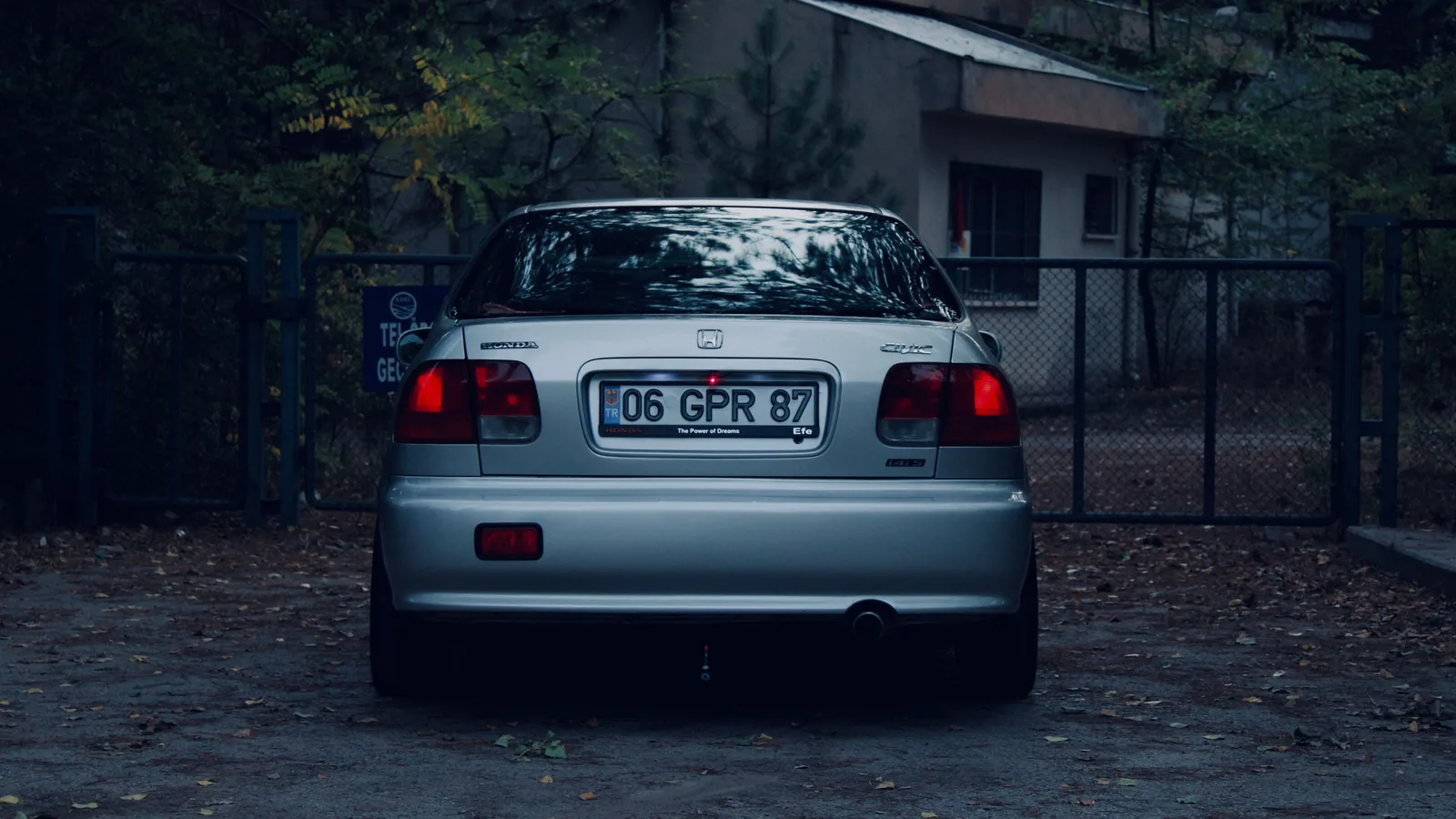 Car parked near the gate of a suburban house, representing personal-use borrowing that falls outside motor vehicle finance
