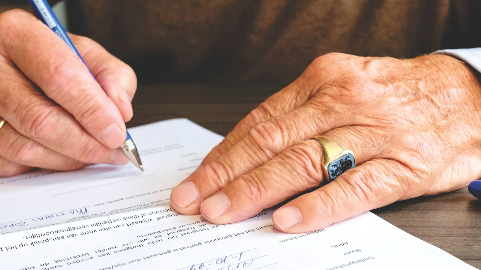 Close-up of a person signing a business finance document