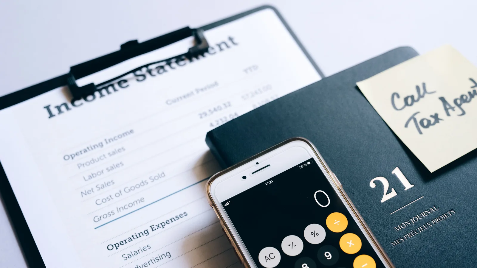 Smartphone calculator resting on a printed income statement, representing tax and GST considerations for business vehicle finance