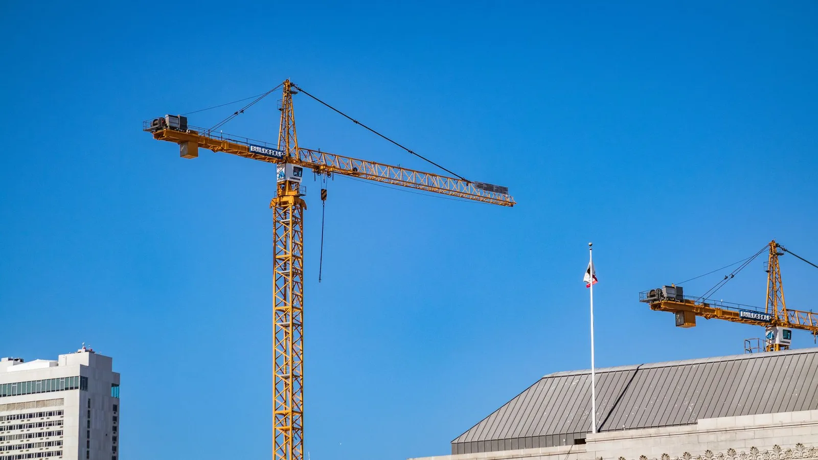 Modern commercial and residential property development construction site in New Zealand with cranes and framing under daylight