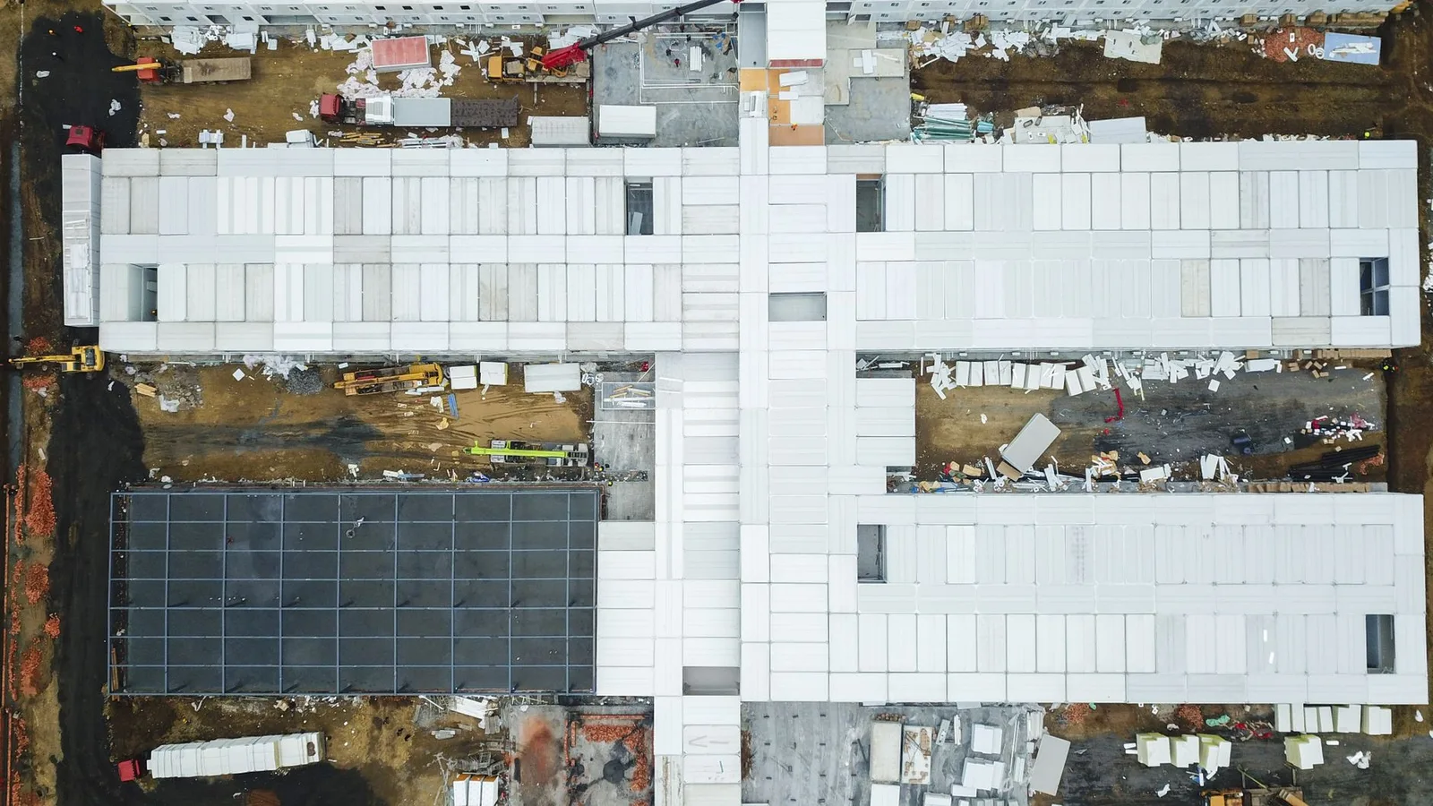 Drone shot capturing aerial view of a large construction site with unfinished buildings