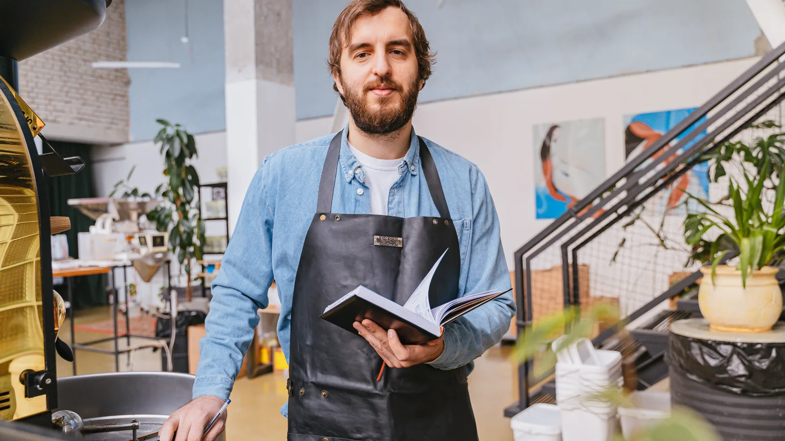 Self-employed small business owner holding a notebook in his workshop, the type of borrower a self-employed business loan in NZ is built to fund