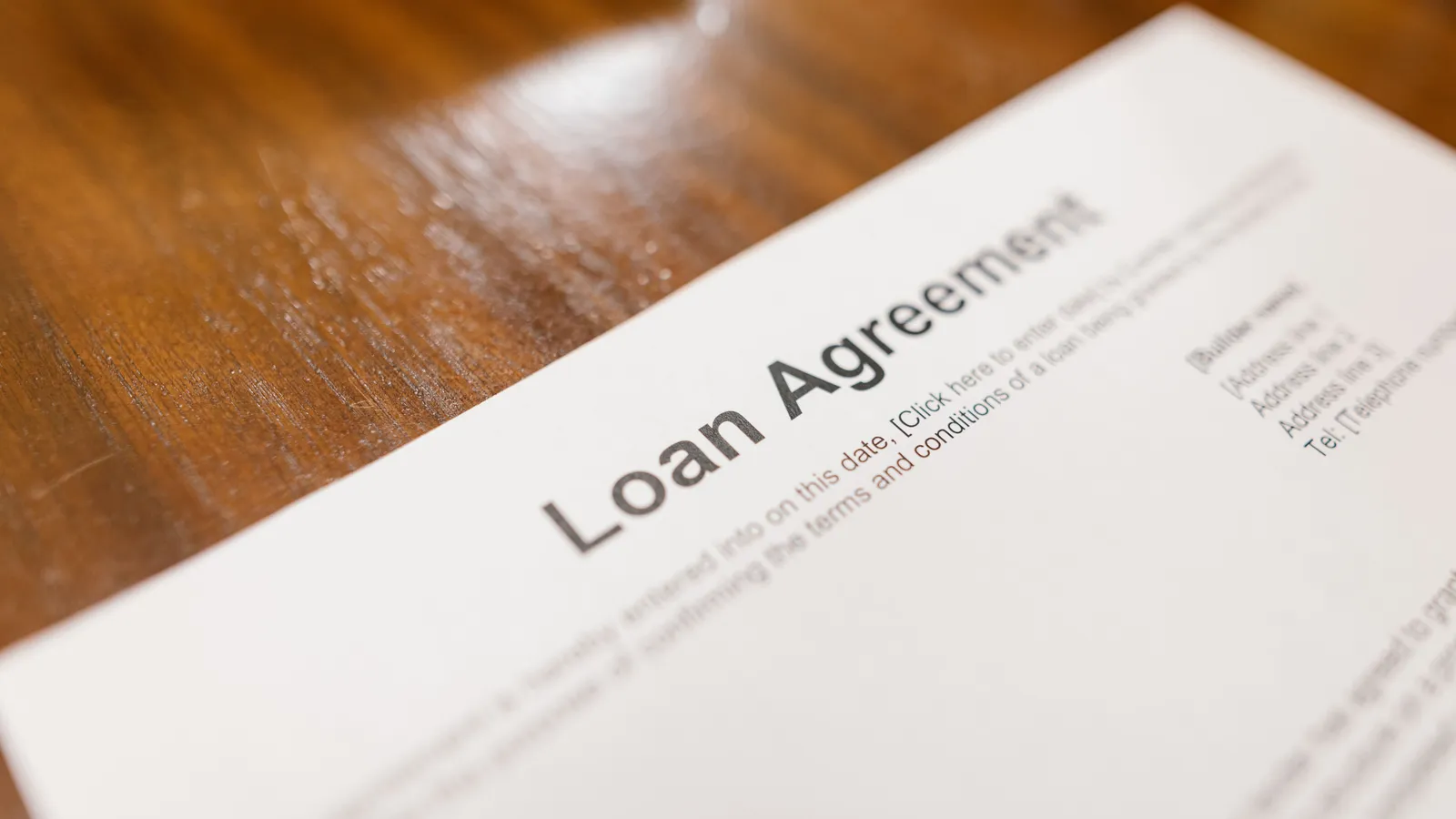 Close-up of a loan agreement document on a wooden table