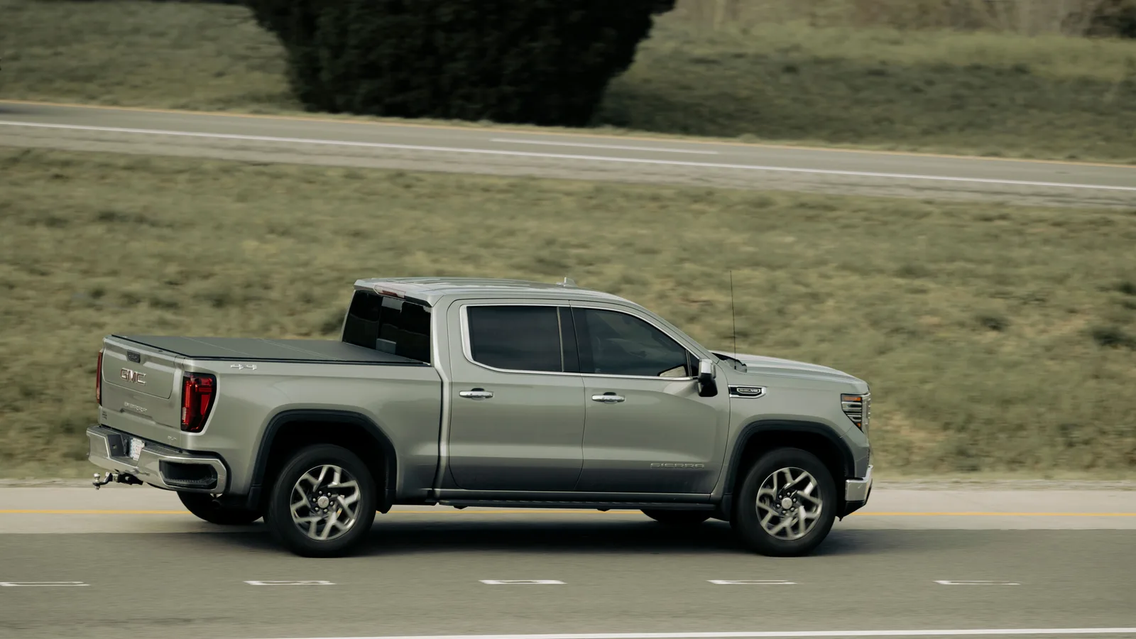 Silver pickup ute travelling along an open New Zealand highway, the type of vehicle funded through ute finance