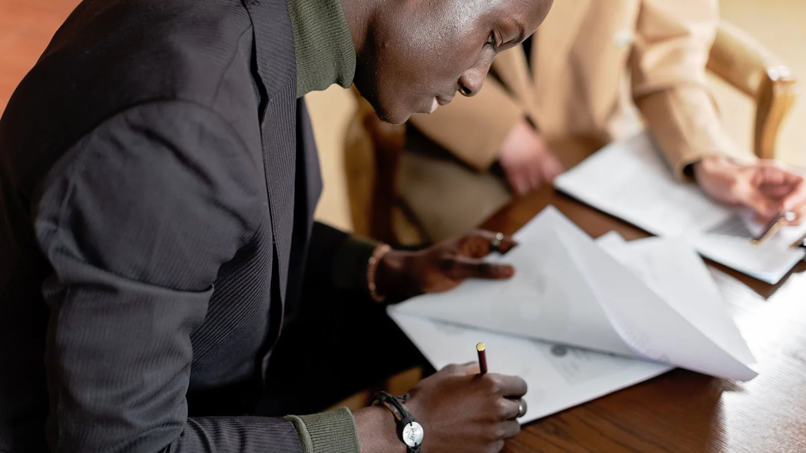 Business owner signing finance documents at a desk