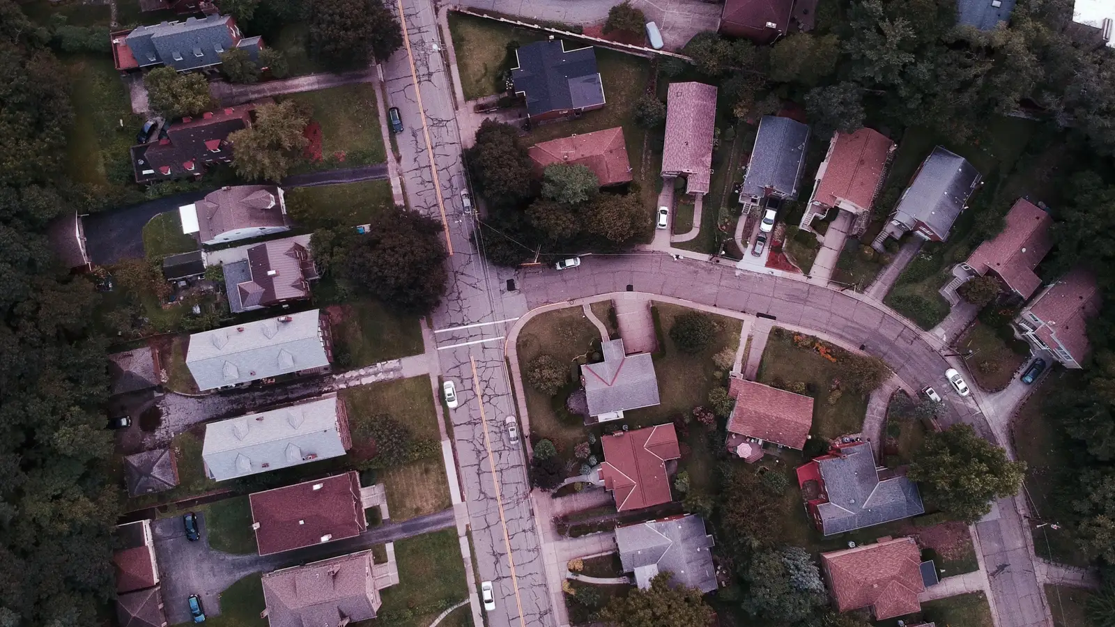 Aerial drone view of a quiet suburban street and houses, representing personal-use borrowing that falls outside commercial van finance