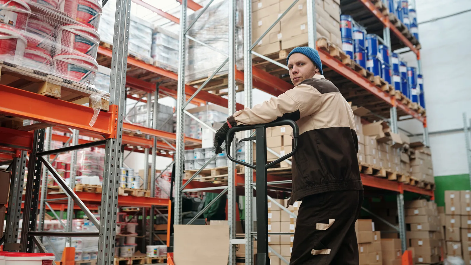 Warehouse worker managing inventory and stock pallets funded through working capital finance